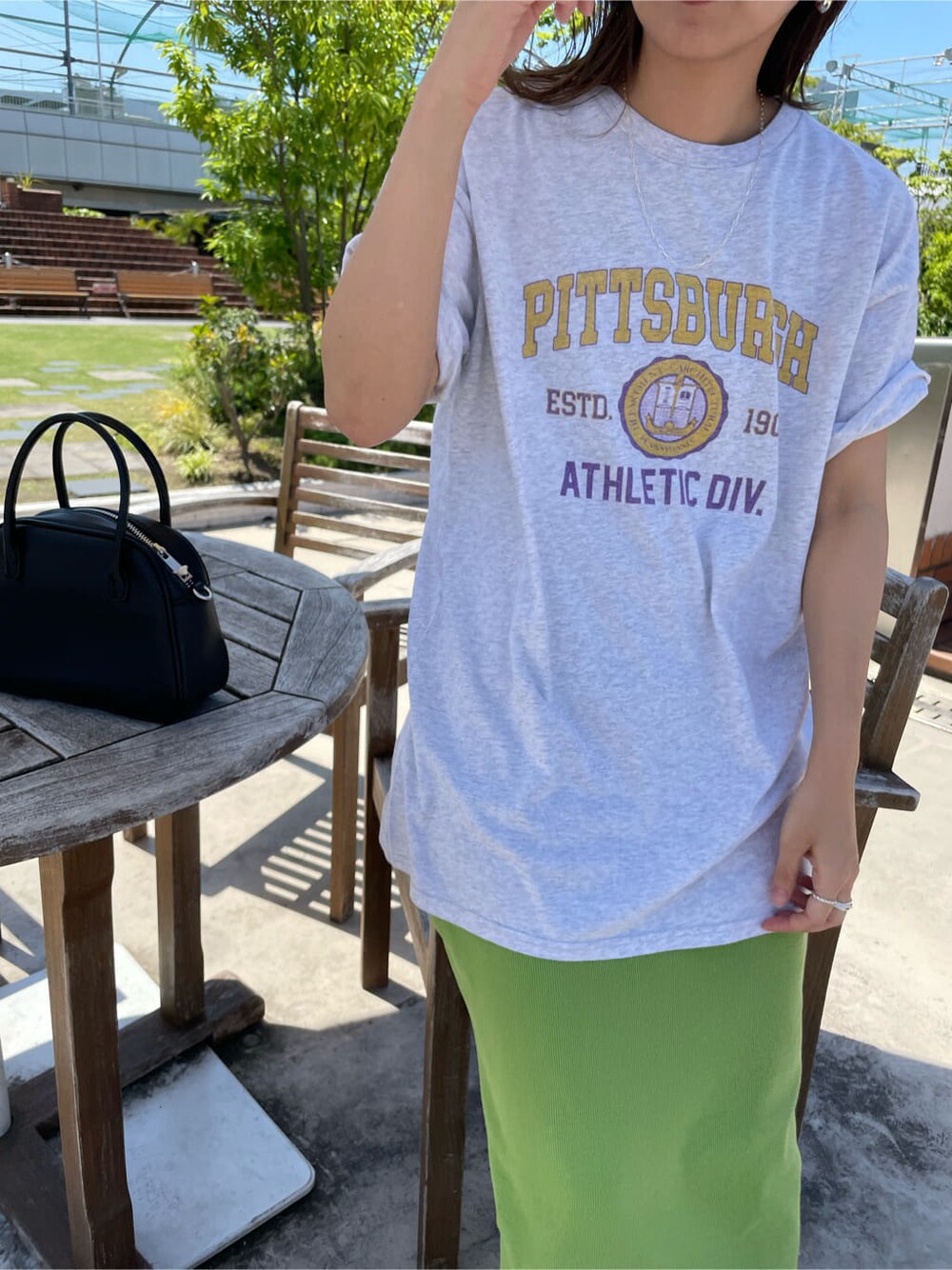 ブラック系のサンダル、ブラック系のハンドバッグ、グレー系のTシャツ/カットソーを着用したレディースの春コーディネートの4枚目の写真