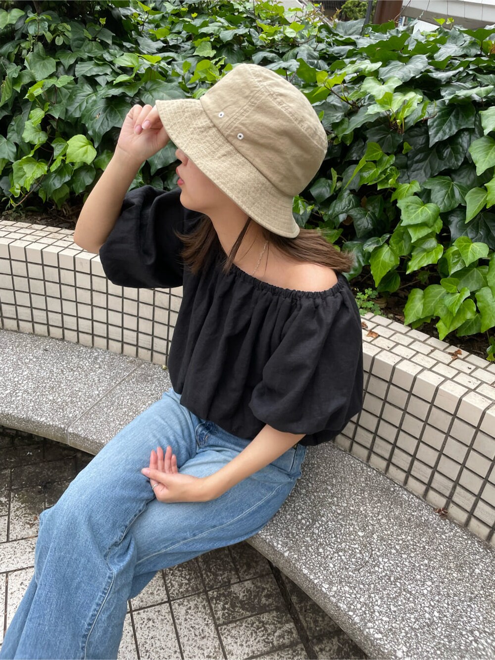 ブラック系のシャツ/ブラウス、ブルー系のデニムパンツ、ホワイト系のハットを着用したレディースの夏コーディネートの2枚目の写真