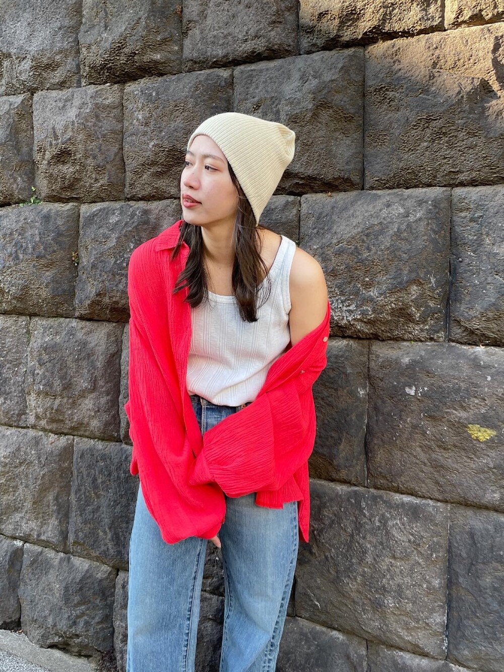 ブルー系のデニムパンツ、オレンジ系のシャツ/ブラウス、ホワイト系のタンクトップを着用したレディースの冬コーディネートの4枚目の写真