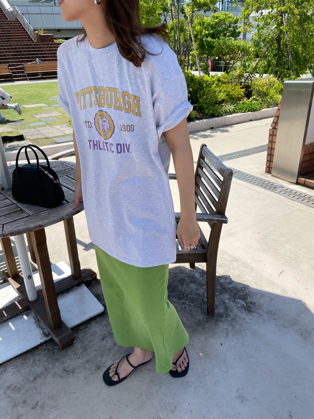 ブラック系のサンダル、ブラック系のハンドバッグ、グレー系のTシャツ/カットソーを着用したレディースの春コーディネートの2枚目の写真