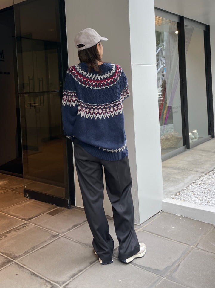 グレー系のスラックス、ブルー系のニット/セーター、グレー系のキャップを着用したレディースの秋コーディネートの4枚目の写真