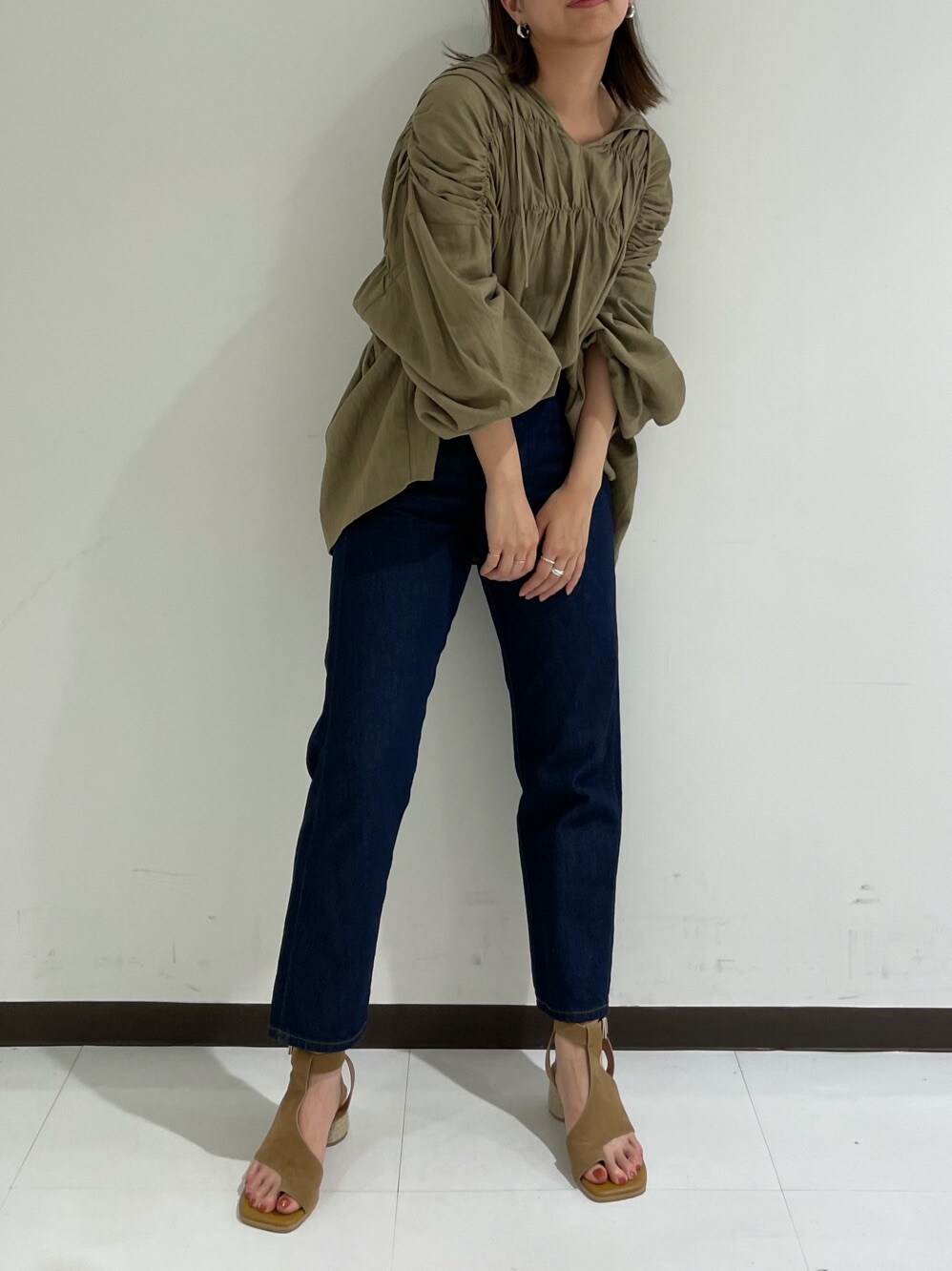 ベージュ系のシャツ/ブラウス、ブラウン系のサンダル、ブルー系のデニムパンツを着用したレディースの春コーディネートの2枚目の写真