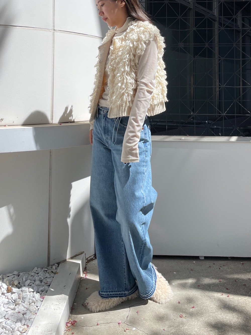 ブルー系のデニムパンツ、ホワイト系のベスト、ホワイト系のTシャツ/カットソーを着用したレディースの夏コーディネートの3枚目の写真