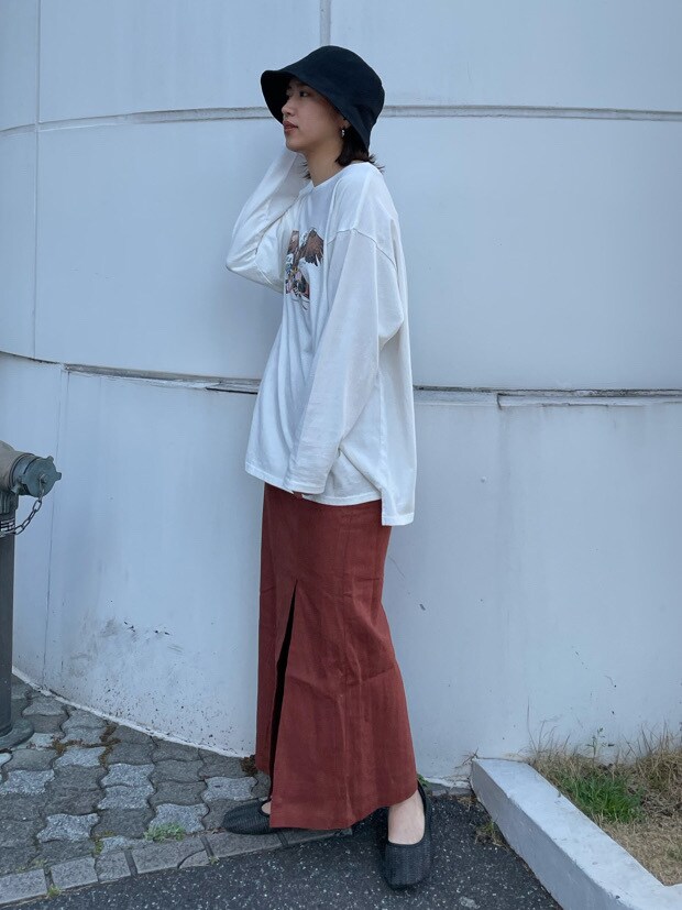 オレンジ系のスカート、ブラック系のその他シューズを着用したレディースの春コーディネートの2枚目の写真