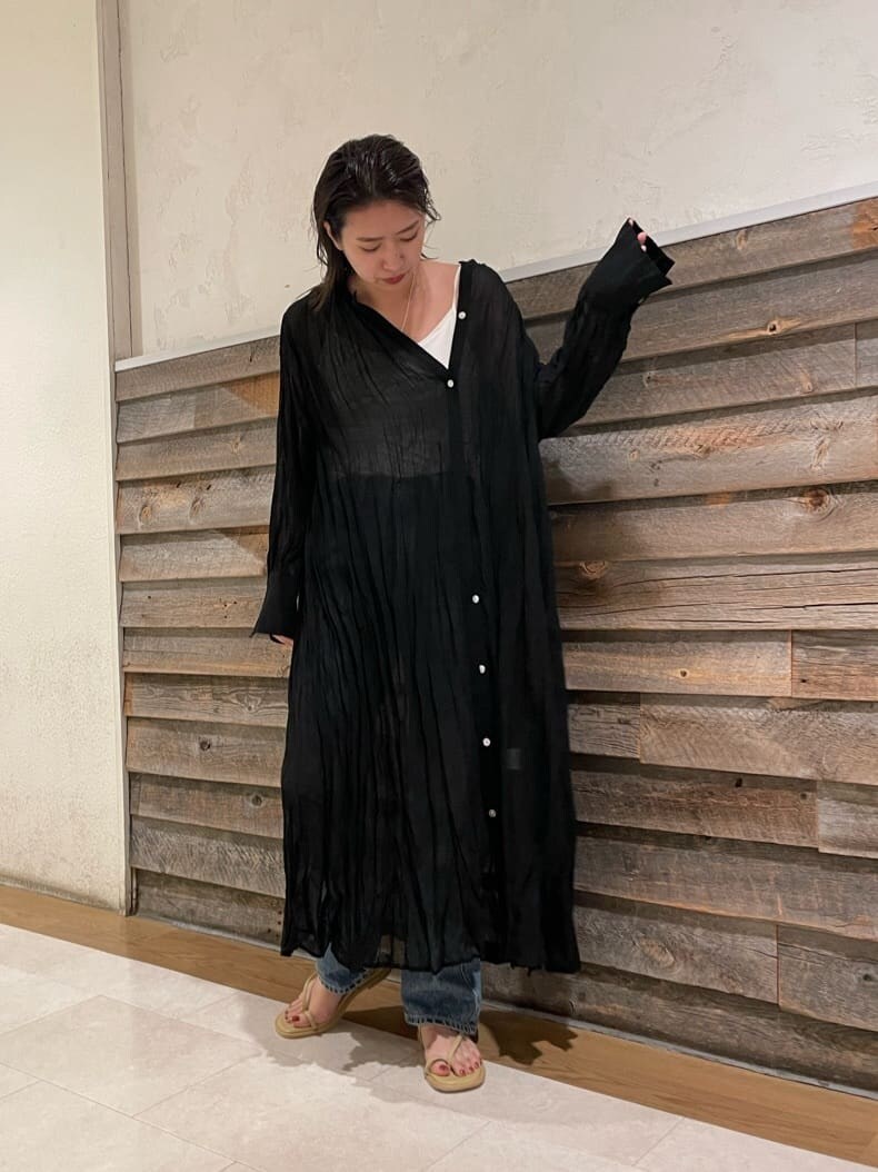 ブルー系のデニムパンツ、ブラック系のワンピース、グリーン系のサンダルを着用したレディースの夏コーディネートの4枚目の写真