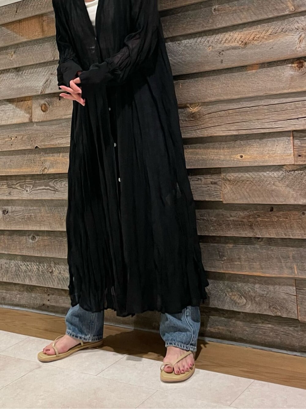 ブルー系のデニムパンツ、ブラック系のワンピース、グリーン系のサンダルを着用したレディースの夏コーディネートの5枚目の写真