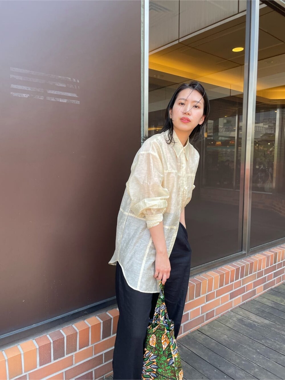 オレンジ系のタンクトップ、ベージュ系のシャツ/ブラウス、ブラック系のその他パンツを着用したレディースの春コーディネートの6枚目の写真