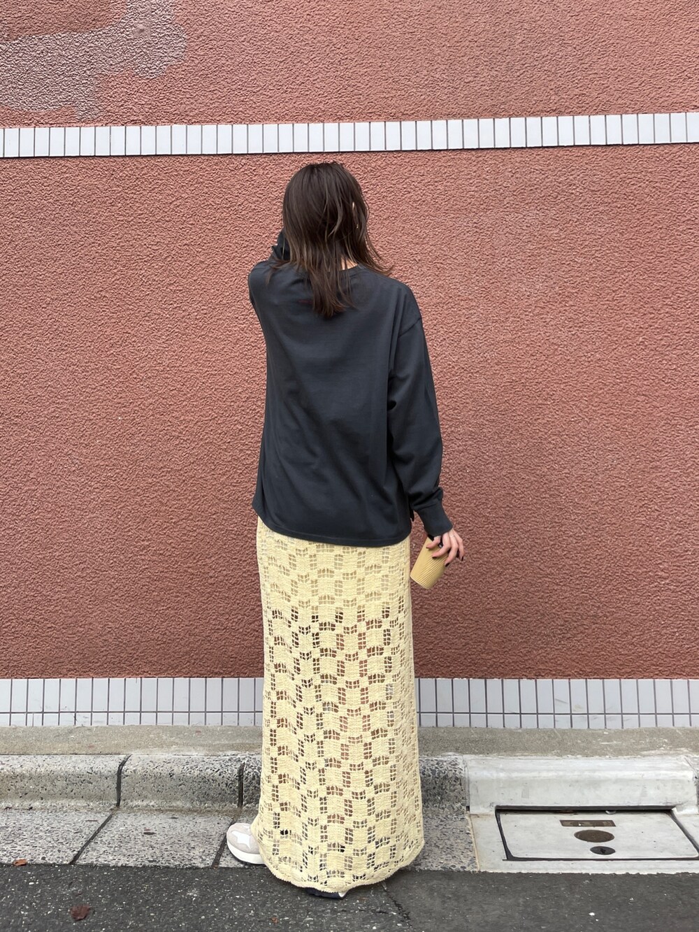 イエロー系のスカート、グレー系のTシャツ/カットソーを着用したレディースの冬コーディネートの3枚目の写真