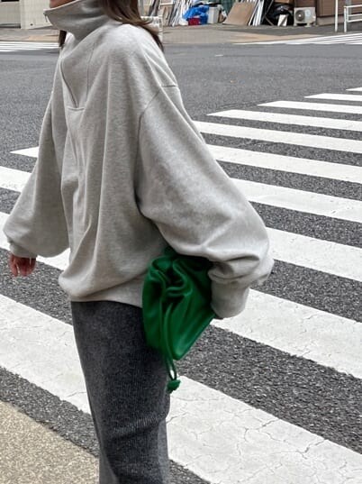 グリーン系のクラッチバッグ、グレー系のスウェット、グレー系のスカートを着用したレディースの秋コーディネートの7枚目の写真