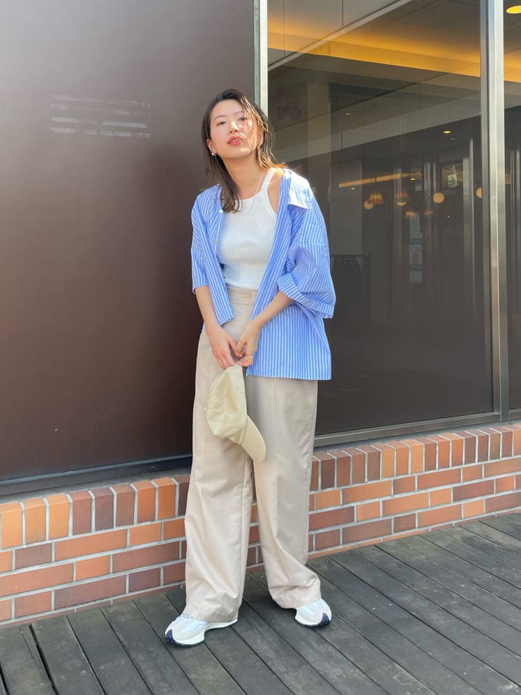 ベージュ系のその他パンツ、ブルー系のシャツ/ブラウス、ホワイト系のタンクトップを着用したレディースの春コーディネートの2枚目の写真