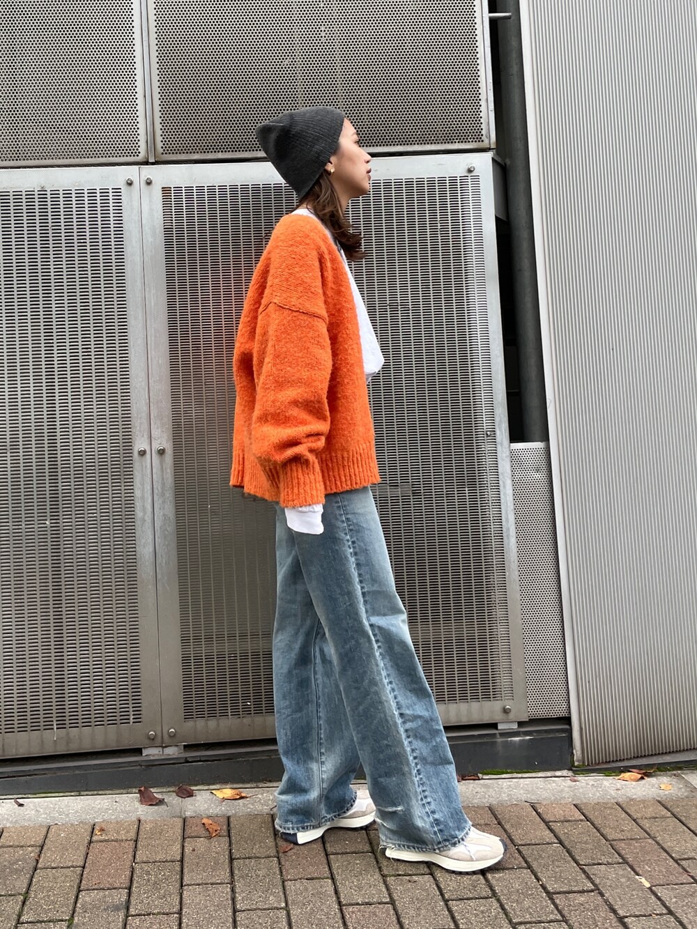 オレンジ系のカーディガン/ボレロ、ブルー系のデニムパンツ、ホワイト系のTシャツ/カットソーを着用したレディースの秋コーディネートの5枚目の写真