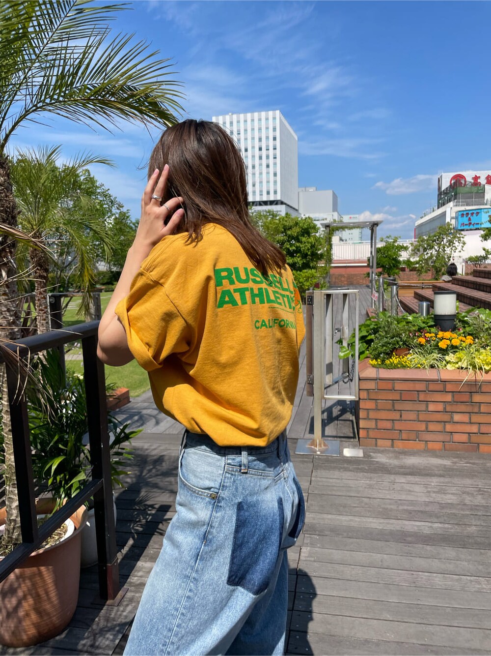 イエロー系のTシャツ/カットソー、ブルー系のデニムパンツを着用したレディースの春コーディネートの3枚目の写真