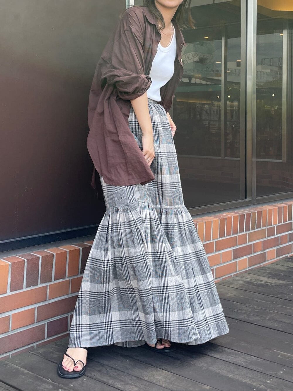 ホワイト系のタンクトップ、ブラウン系のシャツ/ブラウス、ブラック系のスカートを着用したレディースの夏コーディネートの2枚目の写真