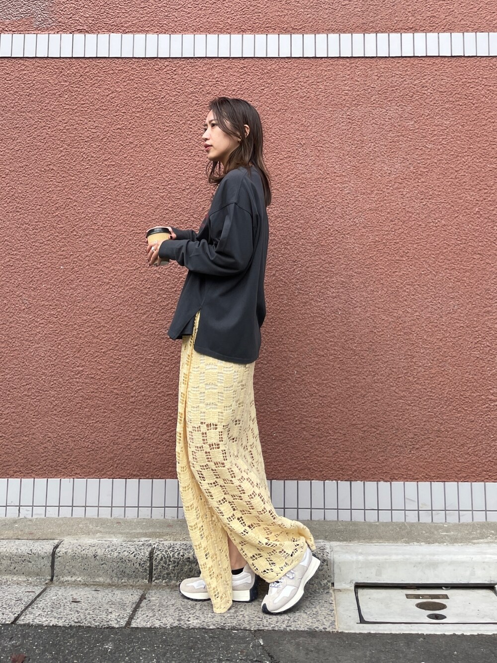 イエロー系のスカート、グレー系のTシャツ/カットソーを着用したレディースの冬コーディネートの2枚目の写真