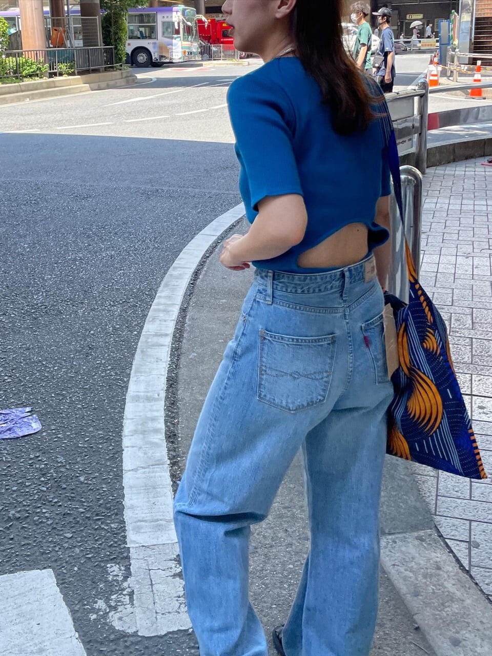 ブルー系のショルダーバッグ、ブルー系のTシャツ/カットソー、ブルー系のデニムパンツを着用したレディースの夏コーディネートの5枚目の写真