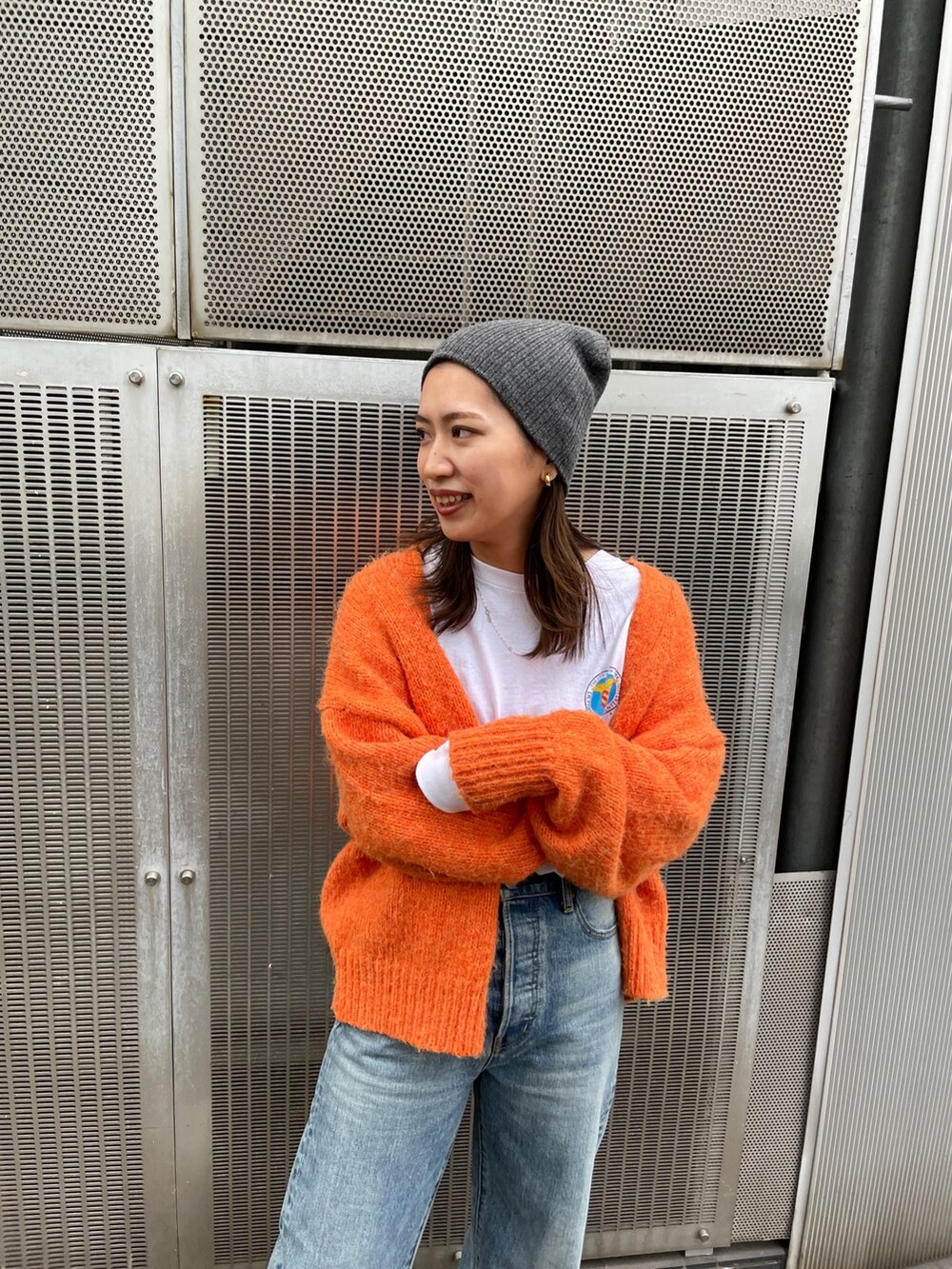 オレンジ系のカーディガン/ボレロ、ブルー系のデニムパンツ、ホワイト系のTシャツ/カットソーを着用したレディースの秋コーディネートの6枚目の写真