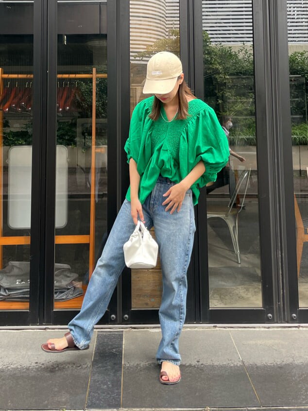 グリーン系のシャツ/ブラウス、ブラウン系のサンダル、ブルー系のデニムパンツを着用したレディースの夏コーディネートの3枚目の写真