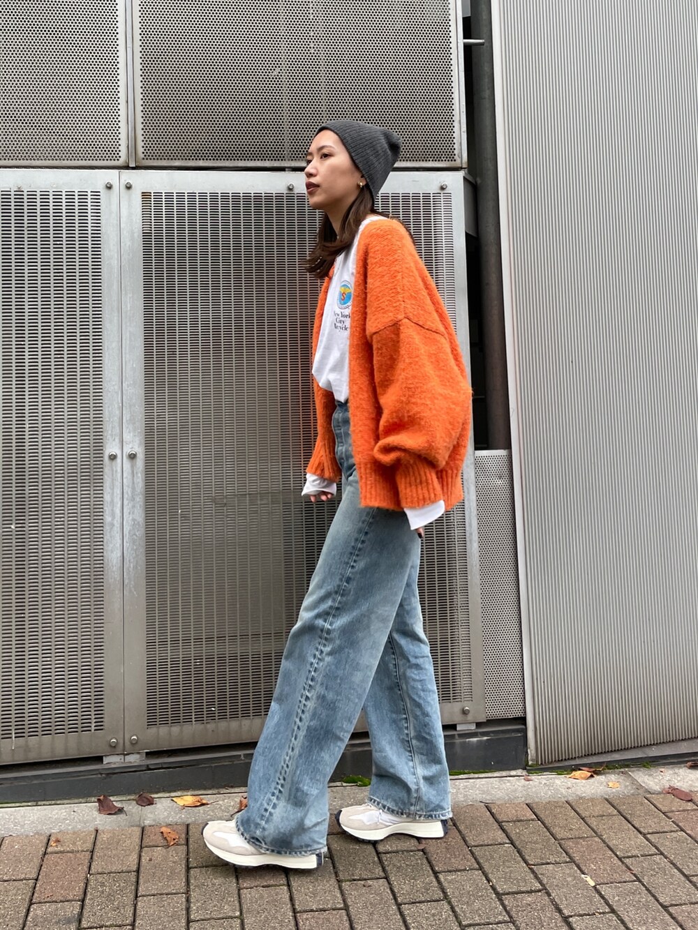 オレンジ系のカーディガン/ボレロ、ブルー系のデニムパンツ、ホワイト系のTシャツ/カットソーを着用したレディースの秋コーディネートの2枚目の写真