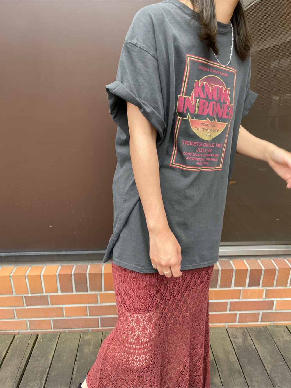 グレー系のTシャツ/カットソー、オレンジ系のスカート、ブラウン系のハットを着用したレディースの春コーディネートの6枚目の写真