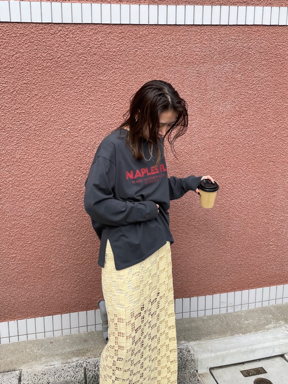 イエロー系のスカート、グレー系のTシャツ/カットソーを着用したレディースの冬コーディネートの7枚目の写真