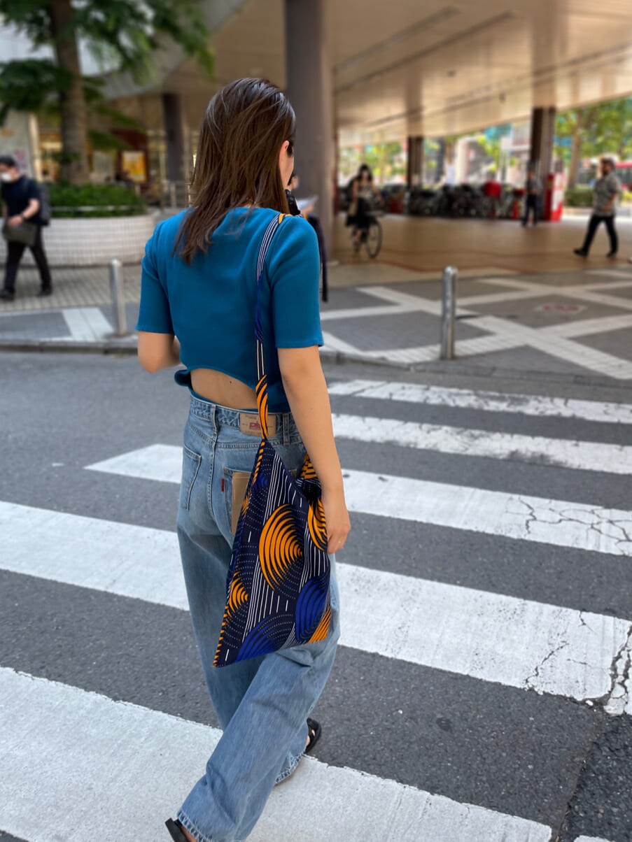 ブルー系のショルダーバッグ、ブルー系のTシャツ/カットソー、ブルー系のデニムパンツを着用したレディースの夏コーディネートの7枚目の写真