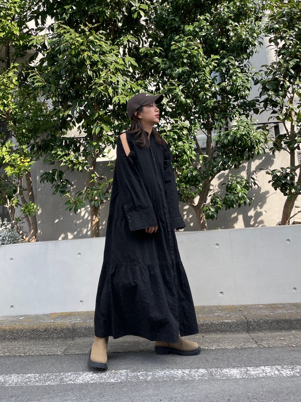 ブラック系のワンピース、ベージュ系のブーツ、グレー系のキャップを着用したレディースの冬コーディネートの7枚目の写真