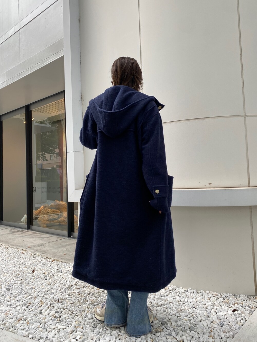 ブルー系のダッフルコート、ブルー系のデニムパンツ、ピンク系のTシャツ/カットソーを着用したレディースの秋コーディネートの3枚目の写真