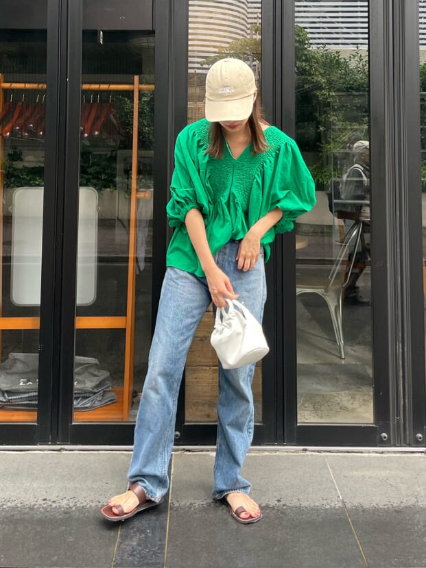 グリーン系のシャツ/ブラウス、ブラウン系のサンダル、ブルー系のデニムパンツを着用したレディースの夏コーディネートの4枚目の写真