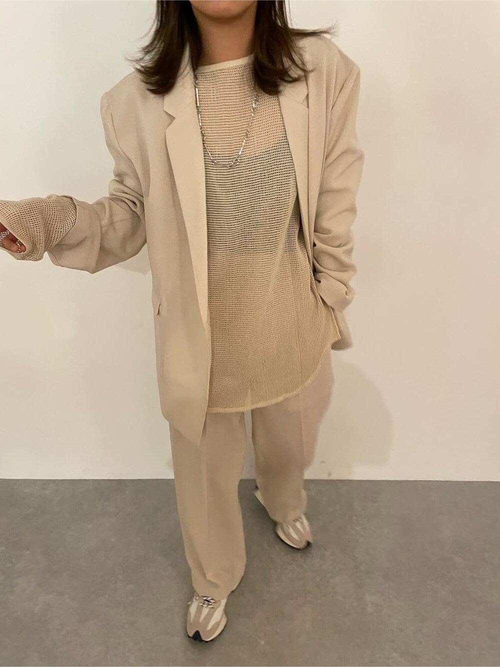 ホワイト系のセットアップ、ホワイト系のTシャツ/カットソー、シルバー系のネックレスを着用したレディースの冬コーディネートの3枚目の写真