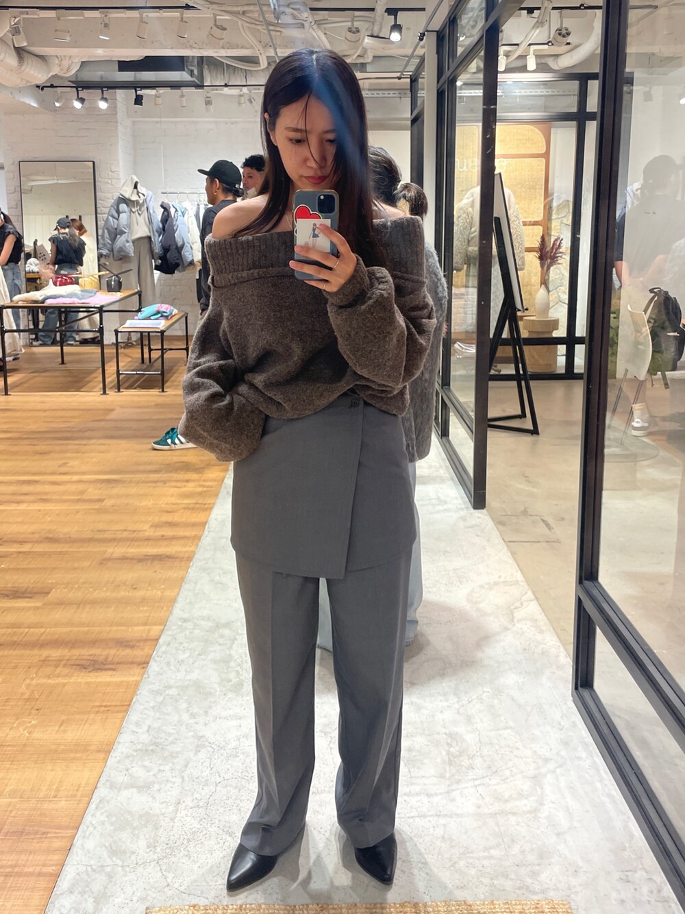 グレー系のその他パンツ、レッド系のニット/セーター、ブラック系のブーツを着用したレディースの秋コーディネートの2枚目の写真