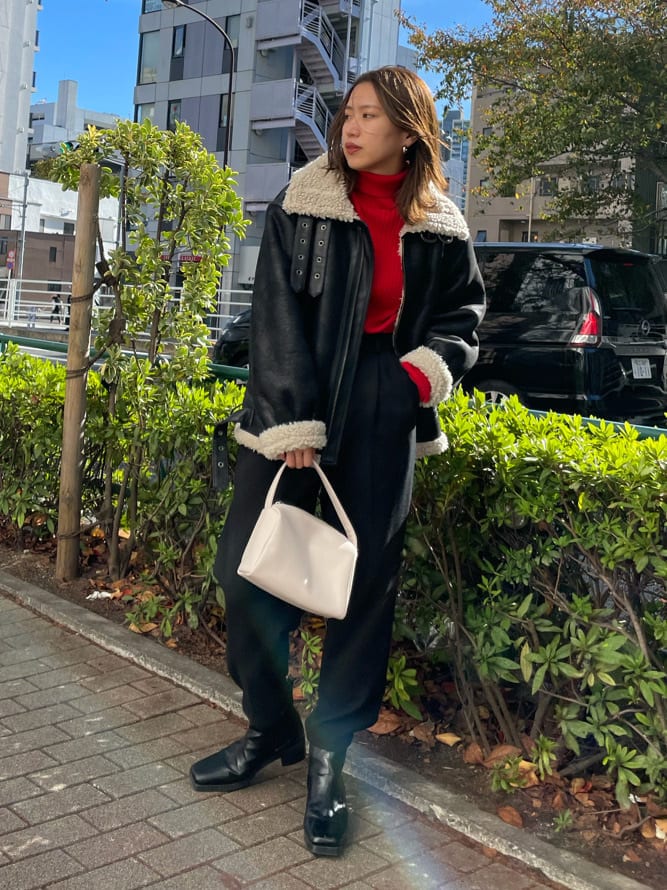 ホワイト系のハンドバッグ、ブラック系のその他パンツ、ブラック系のブルゾンを着用したレディースの秋コーディネートの2枚目の写真