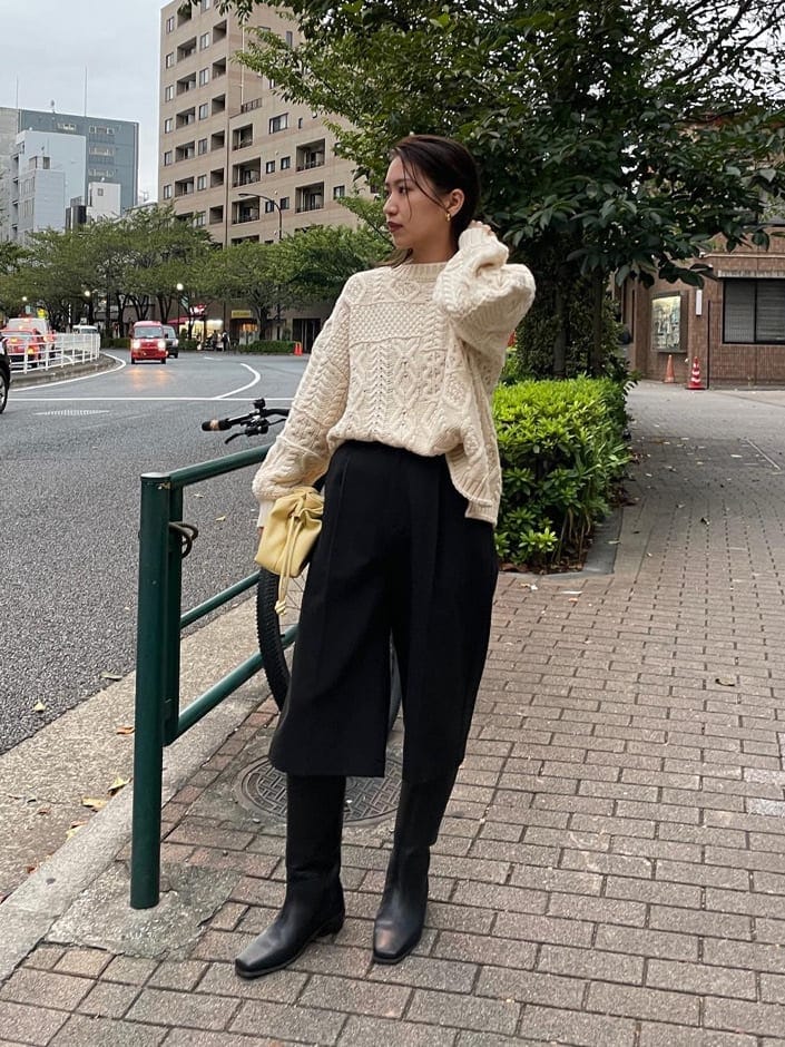 ブラック系のその他パンツ、ブラック系のブーツ、ホワイト系のニット/セーターを着用したレディースの秋コーディネートの2枚目の写真
