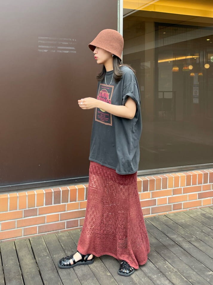 グレー系のTシャツ/カットソー、オレンジ系のスカート、ブラウン系のハットを着用したレディースの春コーディネートの2枚目の写真