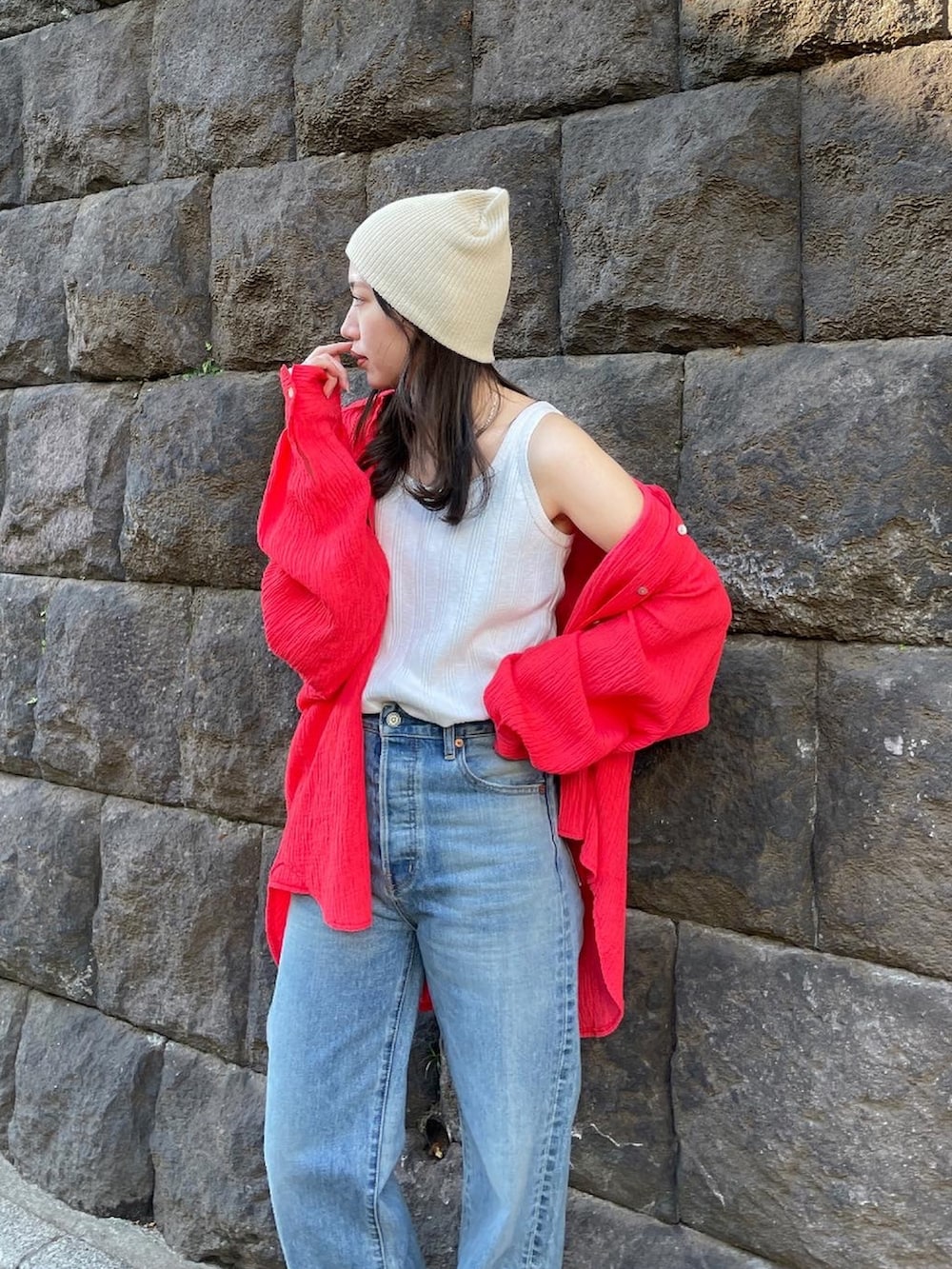 ブルー系のデニムパンツ、オレンジ系のシャツ/ブラウス、ホワイト系のタンクトップを着用したレディースの冬コーディネートの3枚目の写真