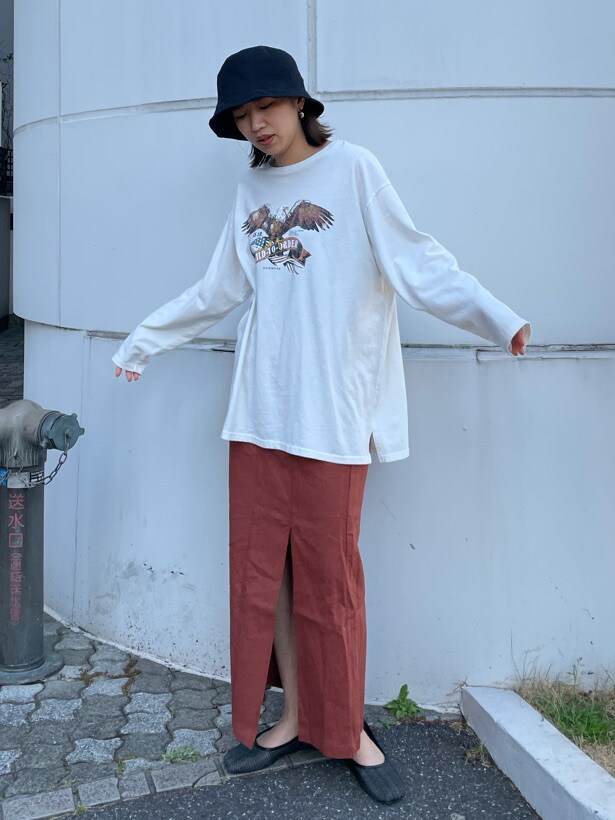 オレンジ系のスカート、ブラック系のその他シューズを着用したレディースの春コーディネートの3枚目の写真