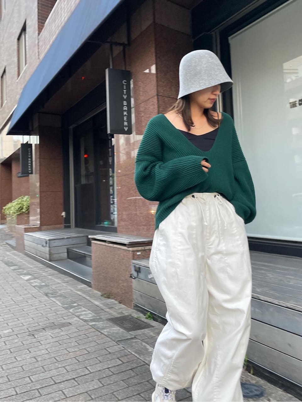 ホワイト系のその他パンツ、グリーン系のニット/セーター、グレー系のハットを着用したレディースの秋コーディネートの3枚目の写真
