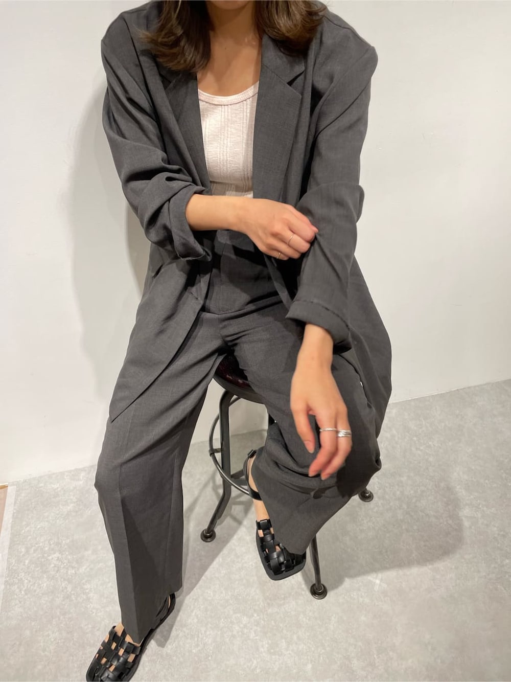 グレー系のセットアップ、ピンク系のタンクトップを着用したレディースの冬コーディネートの2枚目の写真