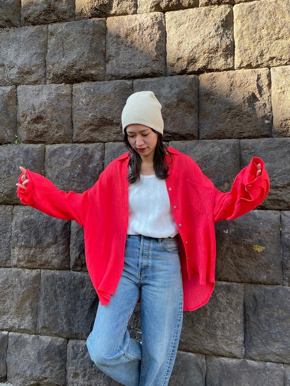 ブルー系のデニムパンツ、オレンジ系のシャツ/ブラウス、ホワイト系のタンクトップを着用したレディースの冬コーディネートの5枚目の写真