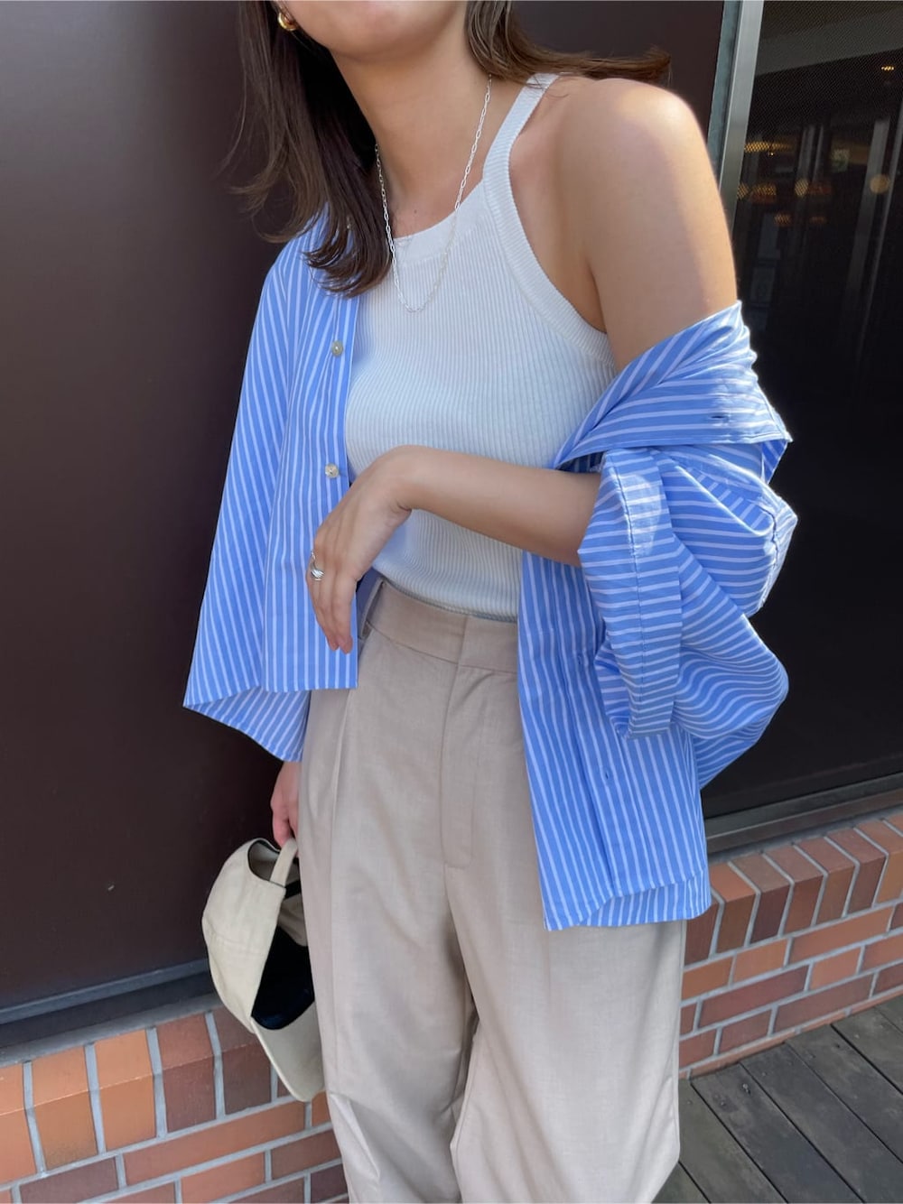 ベージュ系のその他パンツ、ブルー系のシャツ/ブラウス、ホワイト系のタンクトップを着用したレディースの春コーディネートの8枚目の写真