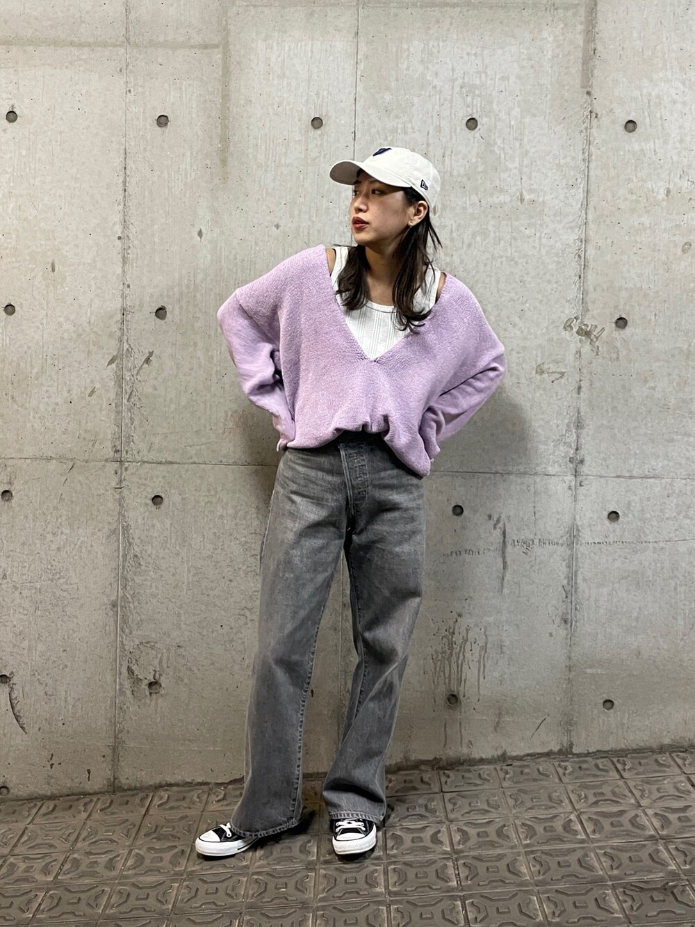 パープル系のニット/セーター、ブラック系のデニムパンツ、ホワイト系のタンクトップを着用したレディースの冬コーディネートの2枚目の写真