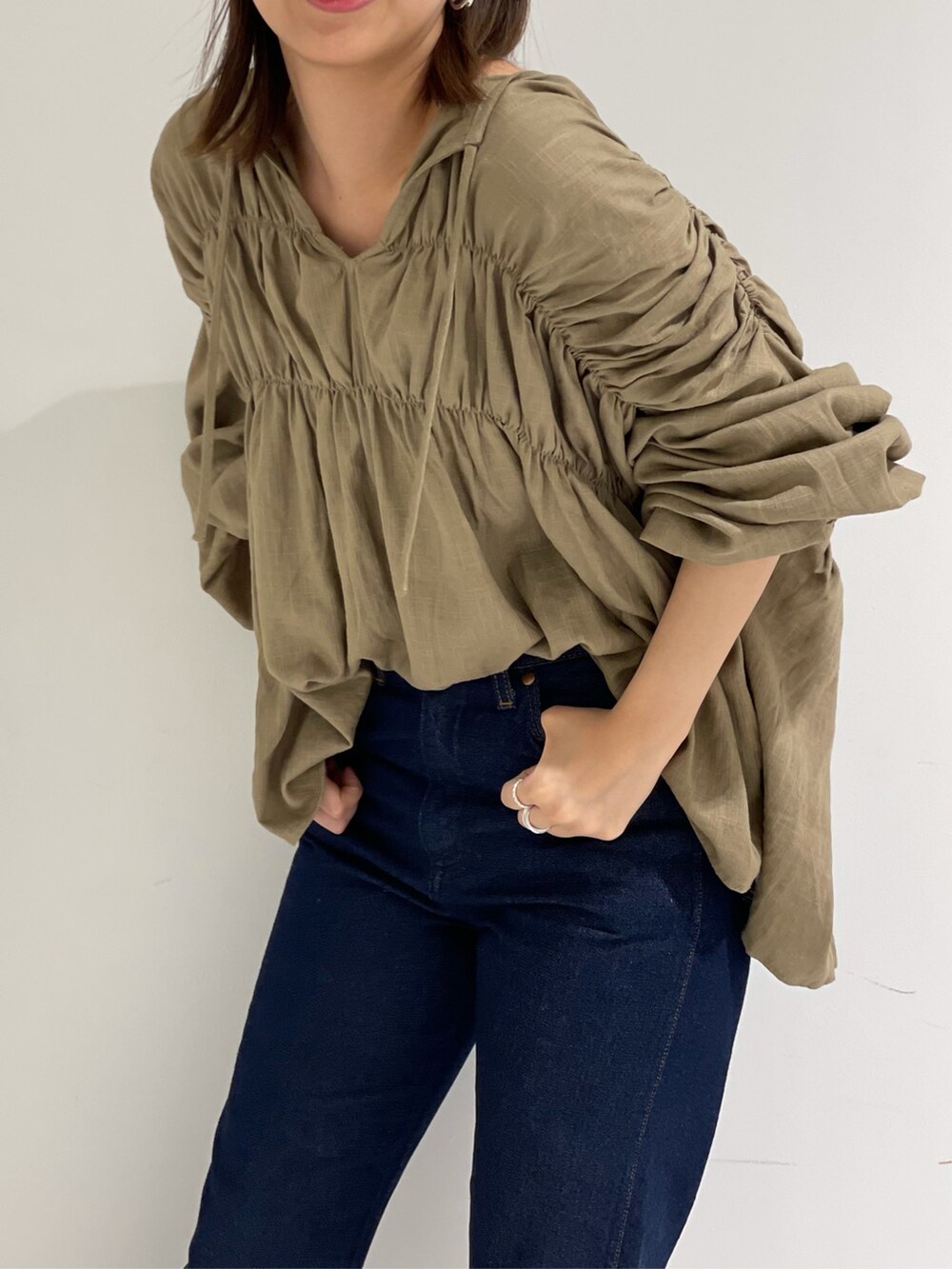 ベージュ系のシャツ/ブラウス、ブラウン系のサンダル、ブルー系のデニムパンツを着用したレディースの春コーディネートの3枚目の写真