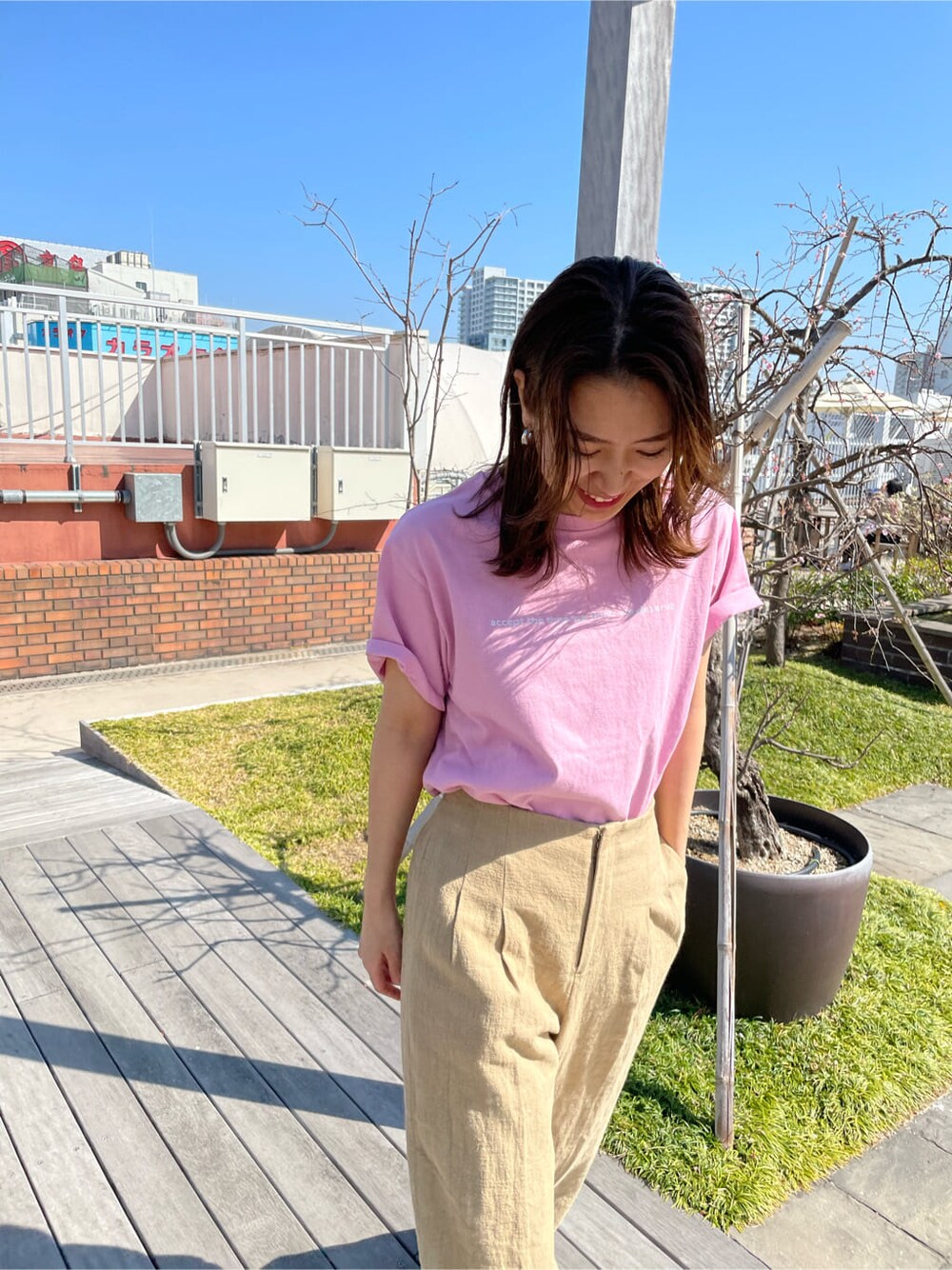 ベージュ系のその他パンツ、ピンク系のTシャツ/カットソー、ホワイト系のサンダルを着用したレディースの春コーディネートの3枚目の写真