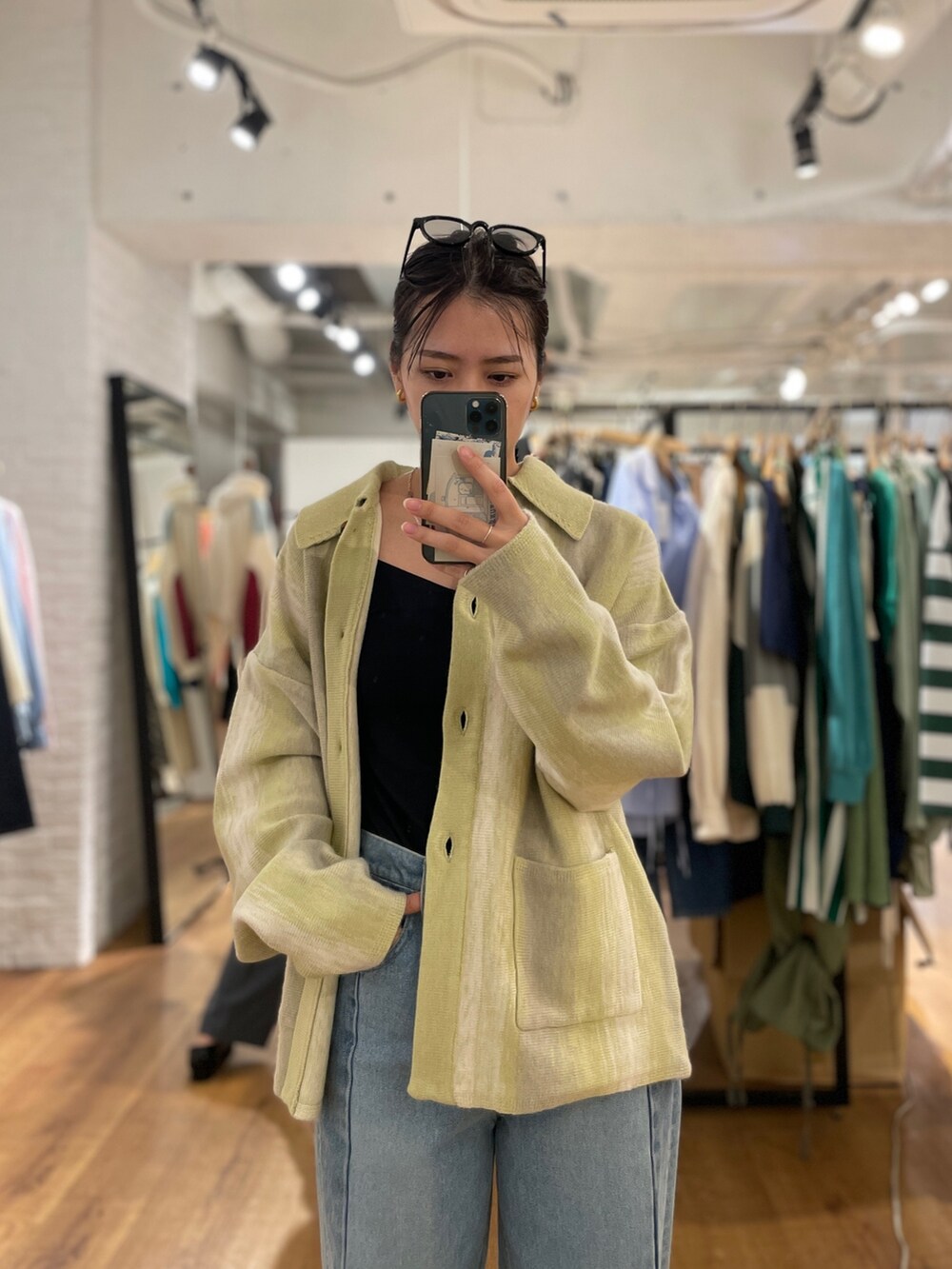 ブルー系のデニムパンツ、グリーン系のカーディガン/ボレロ、ブラック系のパンプスを着用したレディースの秋コーディネートの8枚目の写真