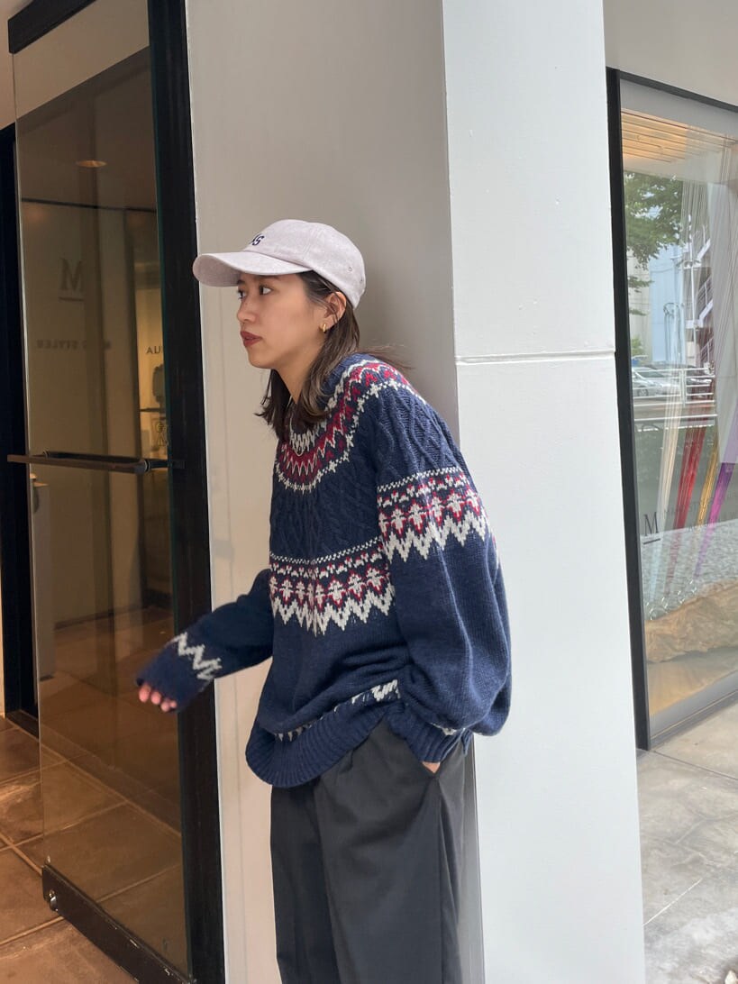 グレー系のスラックス、ブルー系のニット/セーター、グレー系のキャップを着用したレディースの秋コーディネートの7枚目の写真