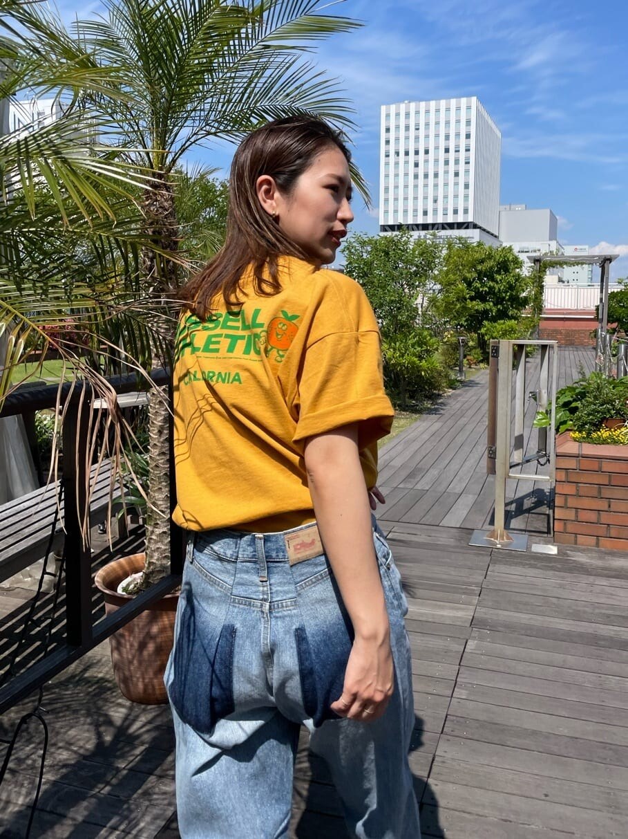 イエロー系のTシャツ/カットソー、ブルー系のデニムパンツを着用したレディースの春コーディネートの4枚目の写真