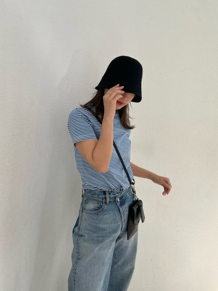 ブラック系のショルダーバッグ、ブルー系のTシャツ/カットソー、ブラック系のサンダルを着用したレディースの春コーディネートの6枚目の写真
