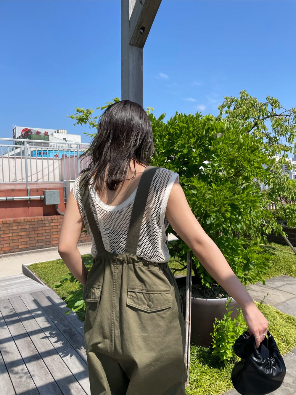 ベージュ系のサロペット/オーバーオール、ブラック系のサンダル、ブラック系のハンドバッグを着用したレディースの春コーディネートの8枚目の写真