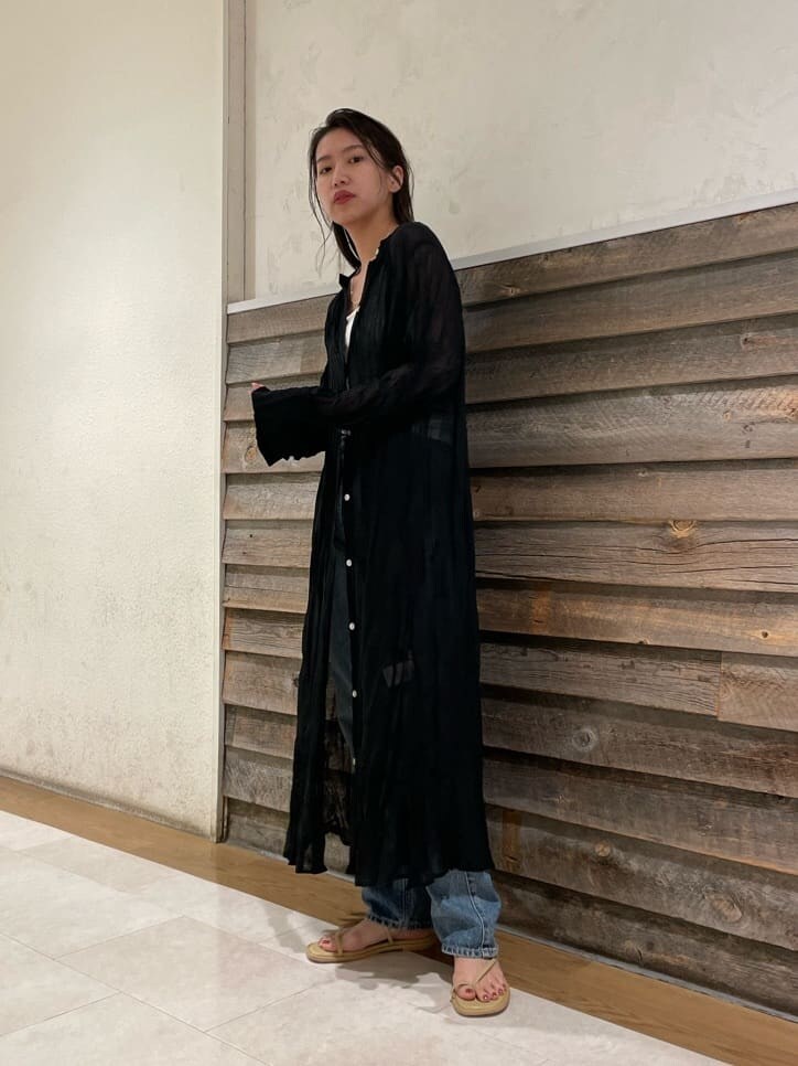 ブルー系のデニムパンツ、ブラック系のワンピース、グリーン系のサンダルを着用したレディースの夏コーディネートの2枚目の写真