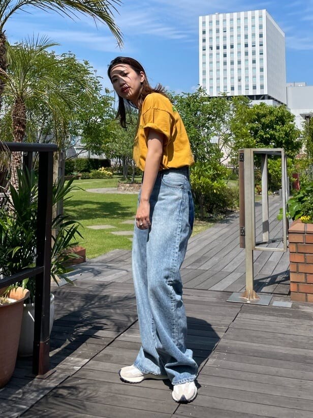 イエロー系のTシャツ/カットソー、ブルー系のデニムパンツを着用したレディースの春コーディネートの2枚目の写真