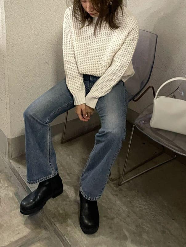 ブルー系のデニムパンツ、ホワイト系のニット/セーターを着用したレディースの秋コーディネートの2枚目の写真